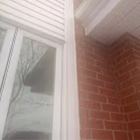 Coin de mur en brique calfeutré à la jonction avec une fenêtre / Brick wall corner caulked where it meets a window