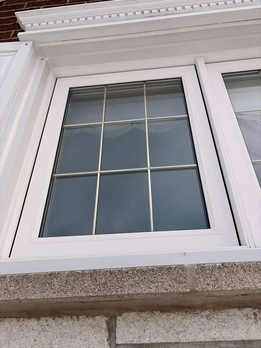 Fenêtre à carreaux calfeutrée sur une maison / Caulked divided-light window on a house